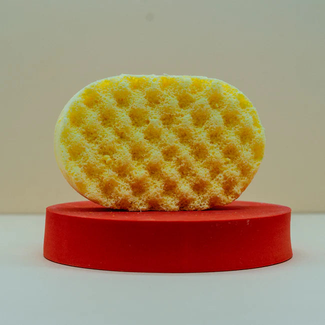 Front View Of A Yellow soap sponge on red surface